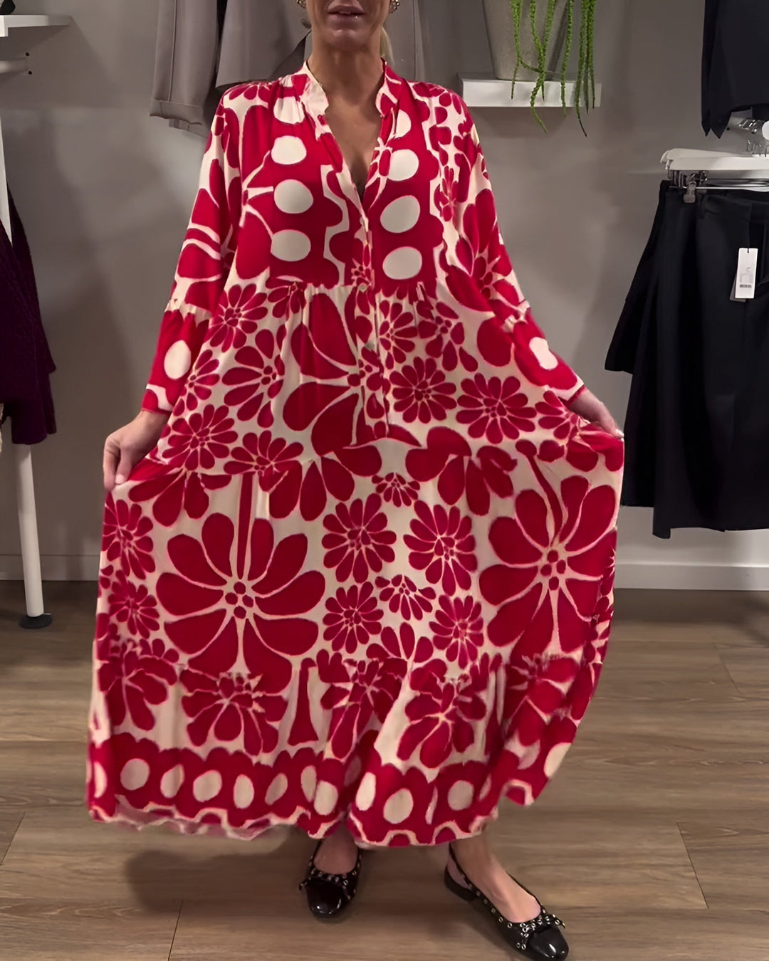 Close-up of elegant print detail on the red Estelle maxi dress showing fabric drape and texture