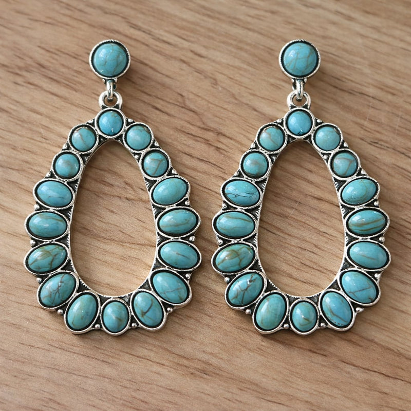 Close-up of vibrant turquoise statement earrings on a clean white background