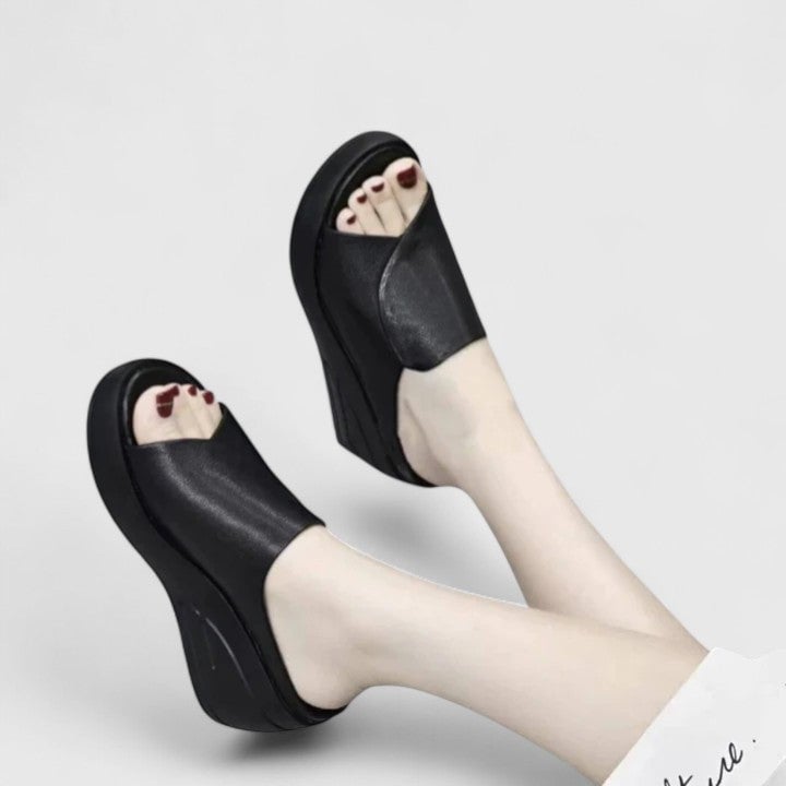 Woman wearing beige orthopedic wedge sandals with cushioned sole and supportive footbed, front view
