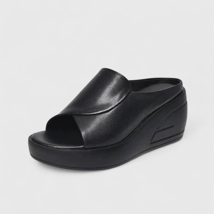 Pair of red orthopedic wedge sandals displayed on neutral background highlighting wedge height and strap detail