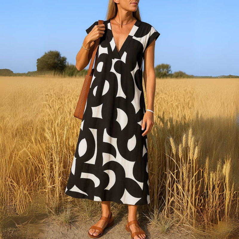 Woman wearing the Evangeline flowy V-neck draped evening dress in black, front view