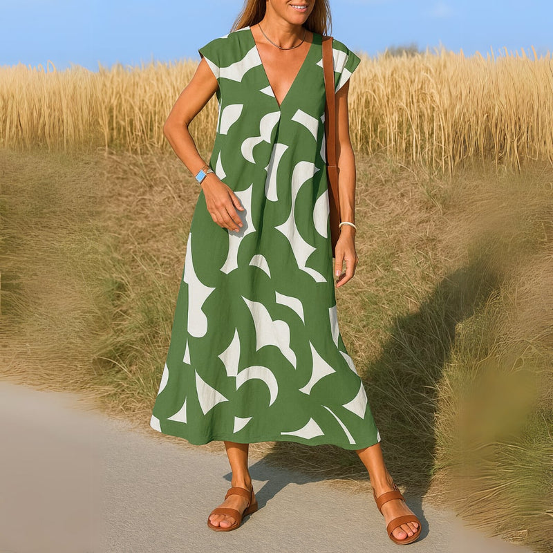 Woman in the Evangeline draped dress in green, showing full-length flowing silhouette