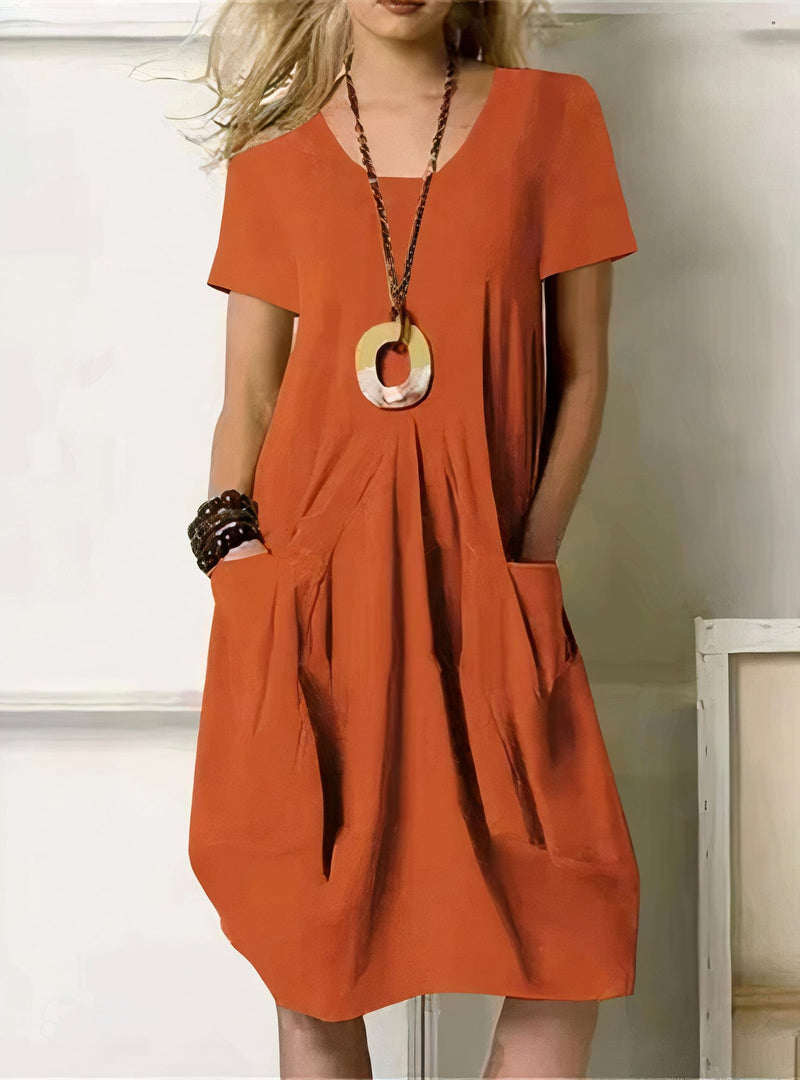 Woman styling the Evelyn relaxed fit dress in black with heeled sandals and accessories