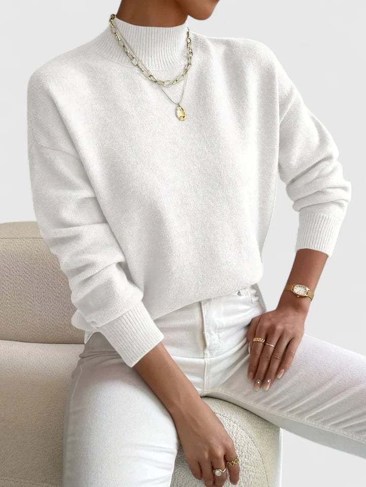 Woman wearing a soft white turtleneck sweater with a classic high-neck design, styled casually