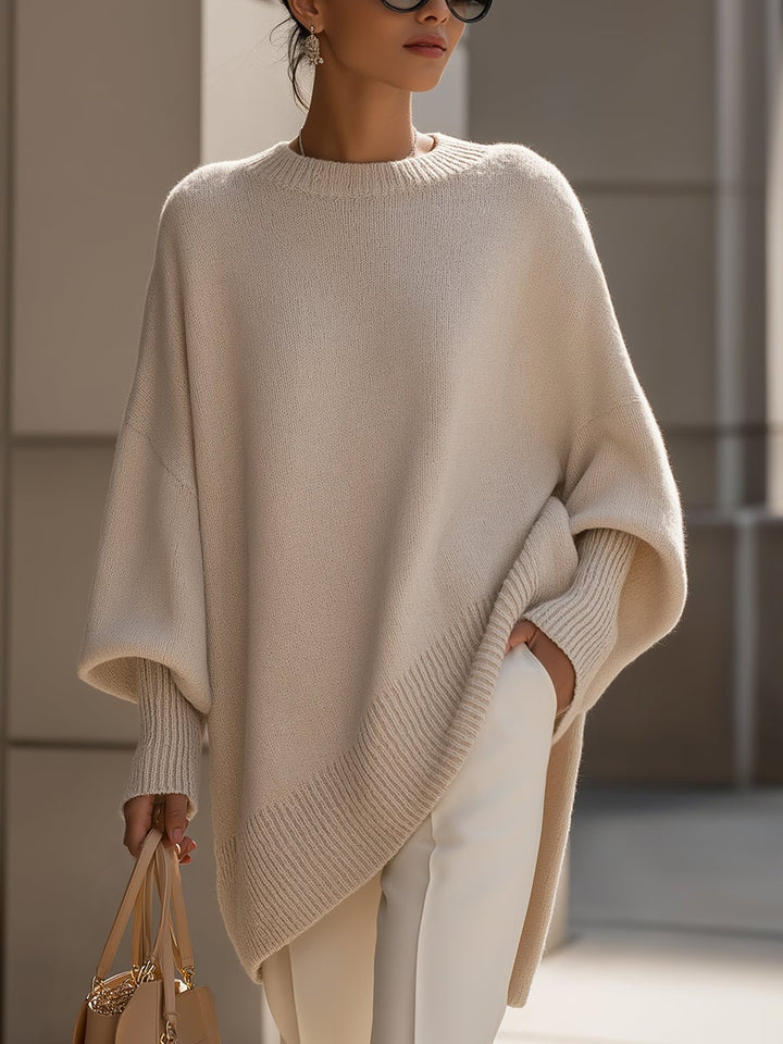 Woman wearing the Faith elegant sweater in beige, styled with tailored trousers for a polished everyday look
