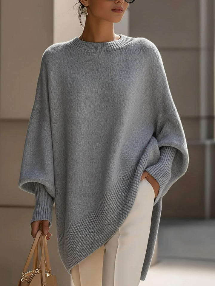 Lifestyle shot of woman wearing the Faith elegant sweater in beige in a bright, casual indoor setting