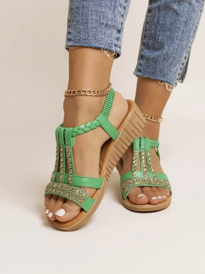 Faith cushioned wedge sandals in black styled with a flowy midi dress, full-length view
