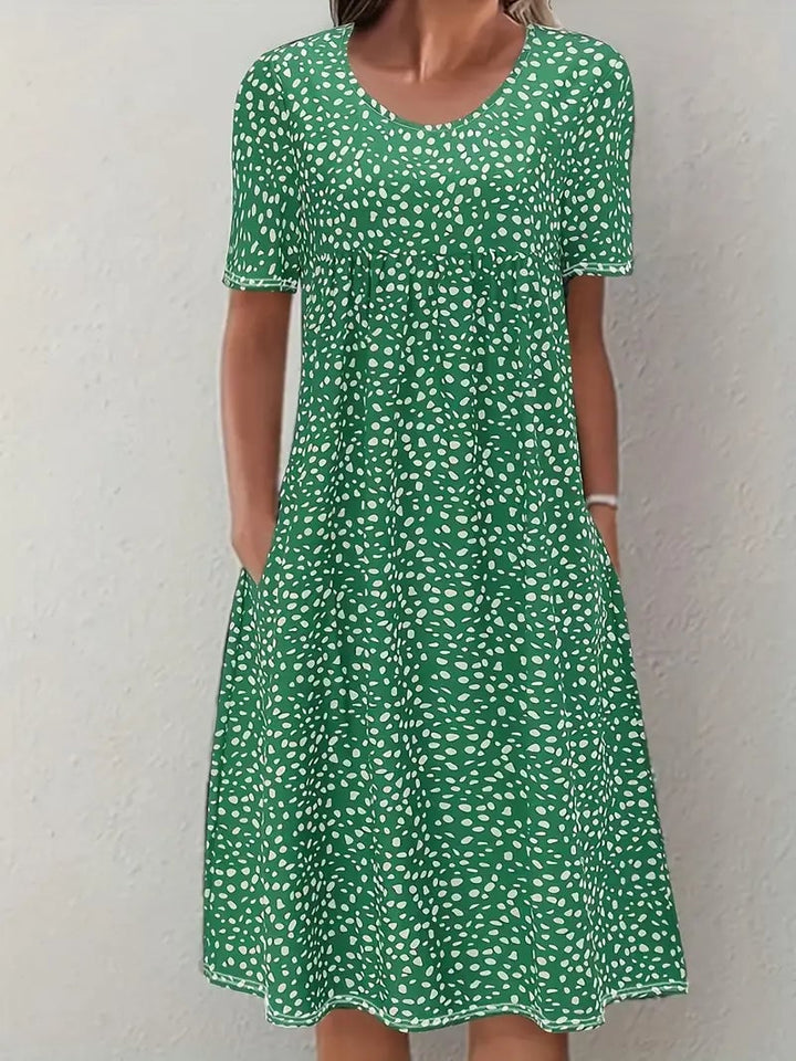 Full-length shot of the Faith flowy evening dress in green, demonstrating the dress's elegant length and fluid drape
