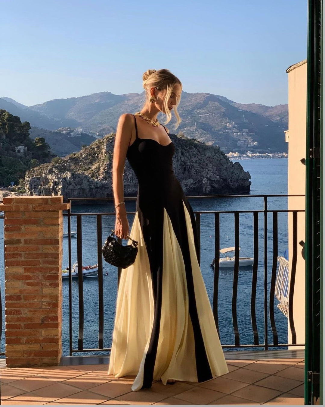 Model posing in the Faye black and white maxi dress at a garden party setting