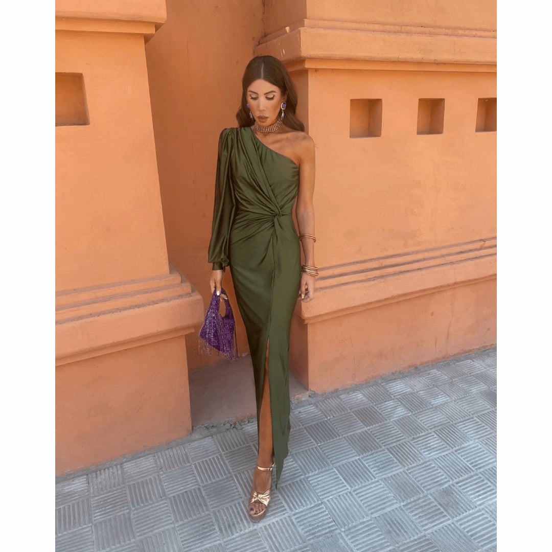 Woman wearing the Felicity evening dress in olive green, showing the full-length silhouette and flowing drape