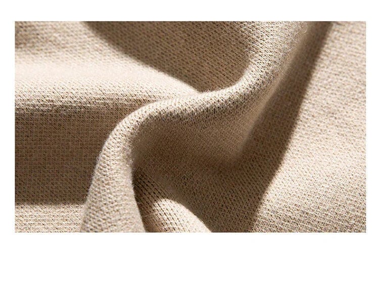 Full-length lifestyle shot of the Moonlit Cat Sweater in beige worn in a cozy indoor setting