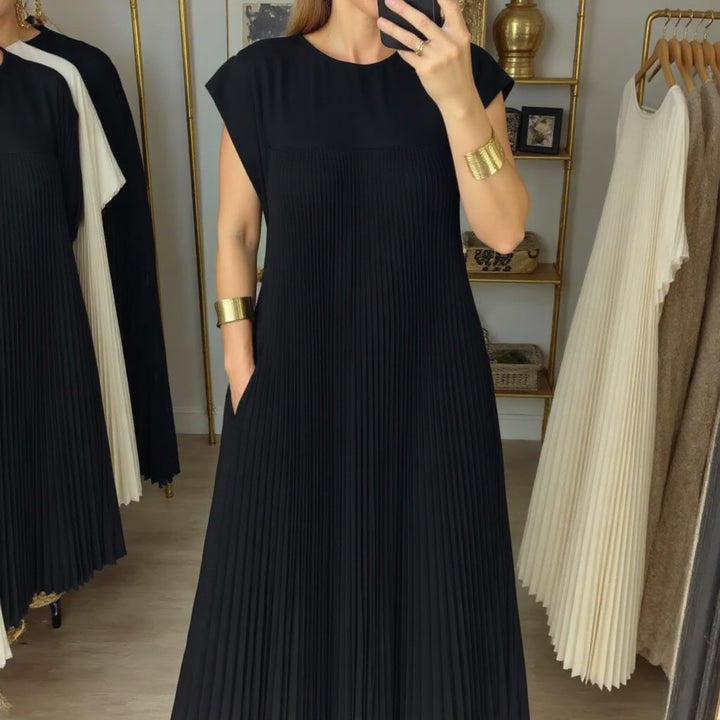 Close-up of the neckline on the Fern flowy pleated maxi dress in beige
