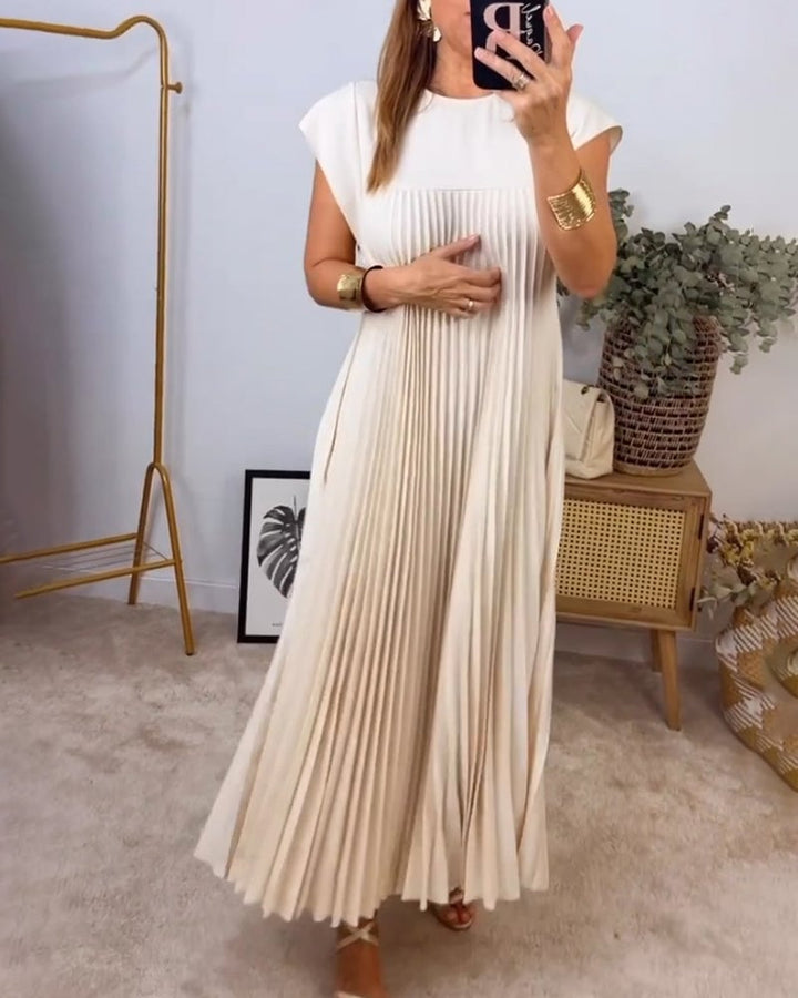 Fern pleated maxi dress in beige showing the hem and floor-length cut