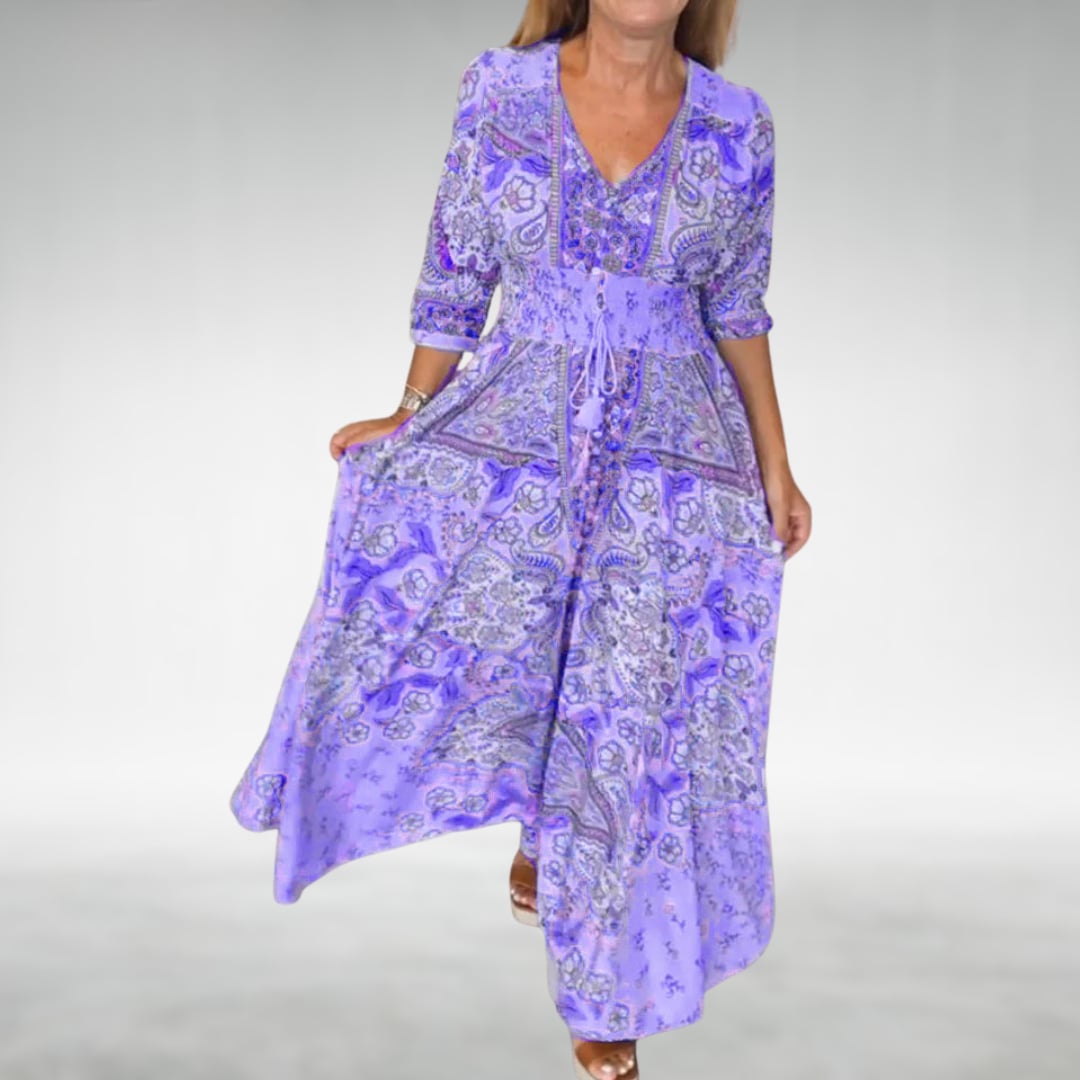 Woman wearing the Flora boho flowy draped maxi dress in purple, showing the full-length silhouette and gathered waist