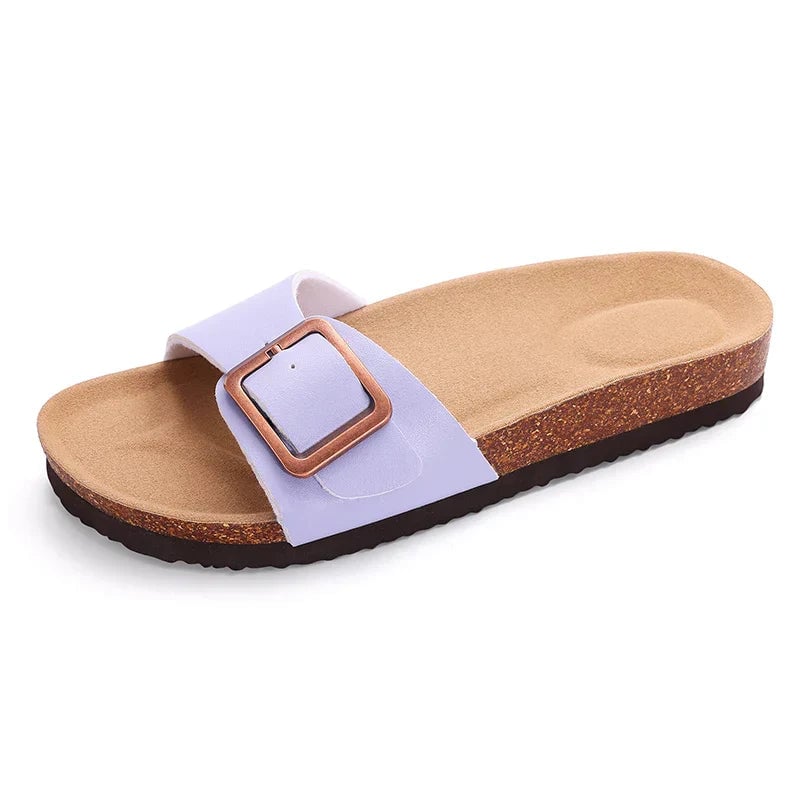 Flat lay of all four Flora sandal colors — pink, black, beige, and purple — arranged together