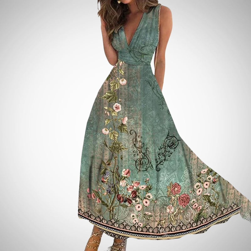 Front view of the Flora floral maxi dress showing the full-sweep skirt and bold botanical print in blue and green colorway