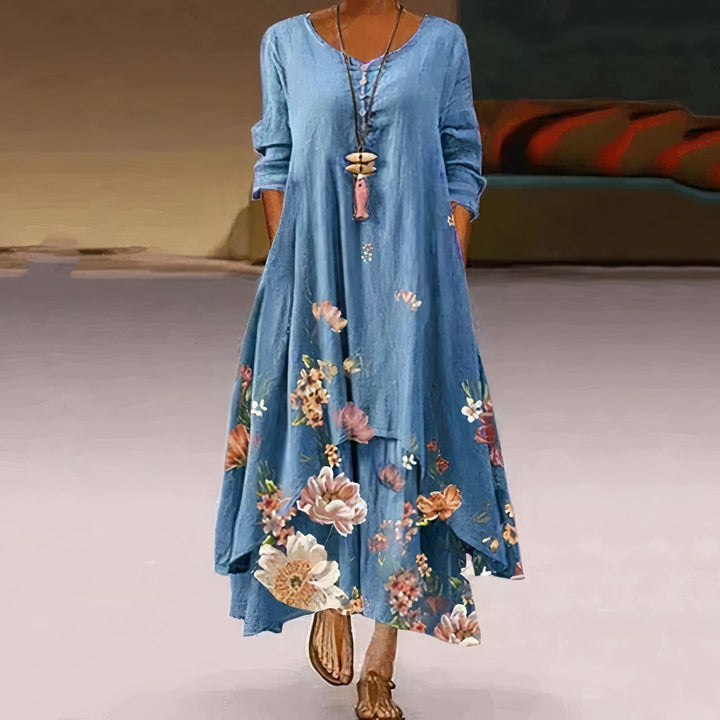 Back view of a floral long sleeve maxi dress in light gray showing flowing A-line shape