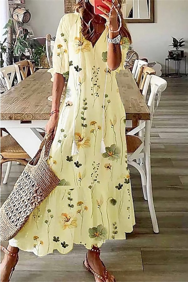 Close-up of the tassel V-neckline detail on a flowing botanical print maxi dress