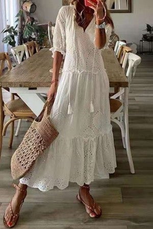 Woman in a yellow floral print tassel maxi dress styled with sandals for a summer outdoor look