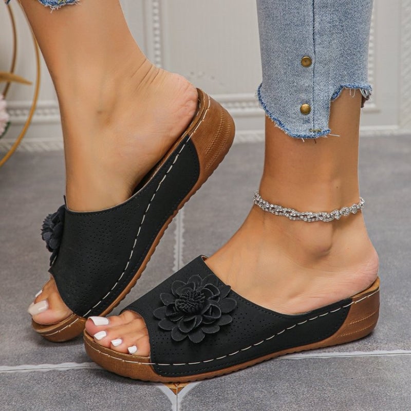 Flora flower wedge slides in blue, three-quarter angle view on neutral background