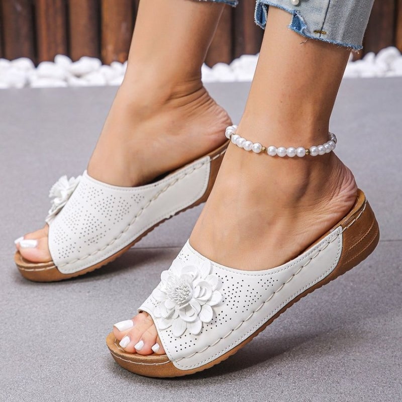 Flora open-toe wedge sandals in black with floral toe detail, top-down view