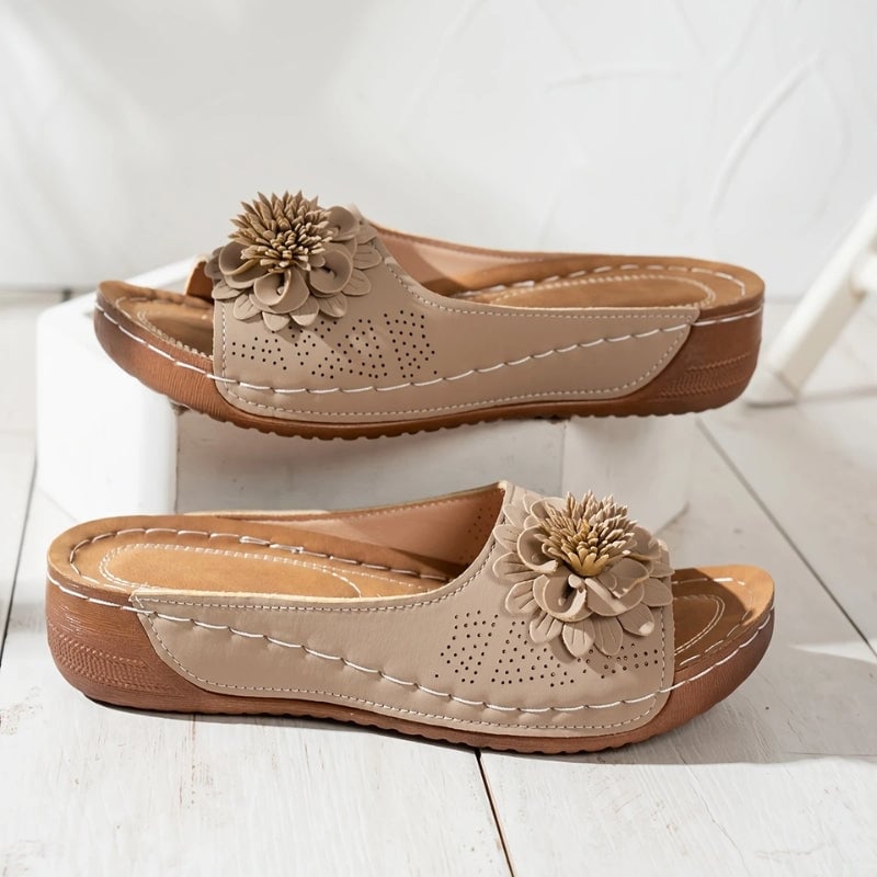 Close-up of 3D floral appliqué detail on Flora wedge slide sandals