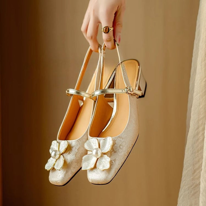 Close-up of pearl-centered floral embellishment on the toe of the Florine slingback pump in beige