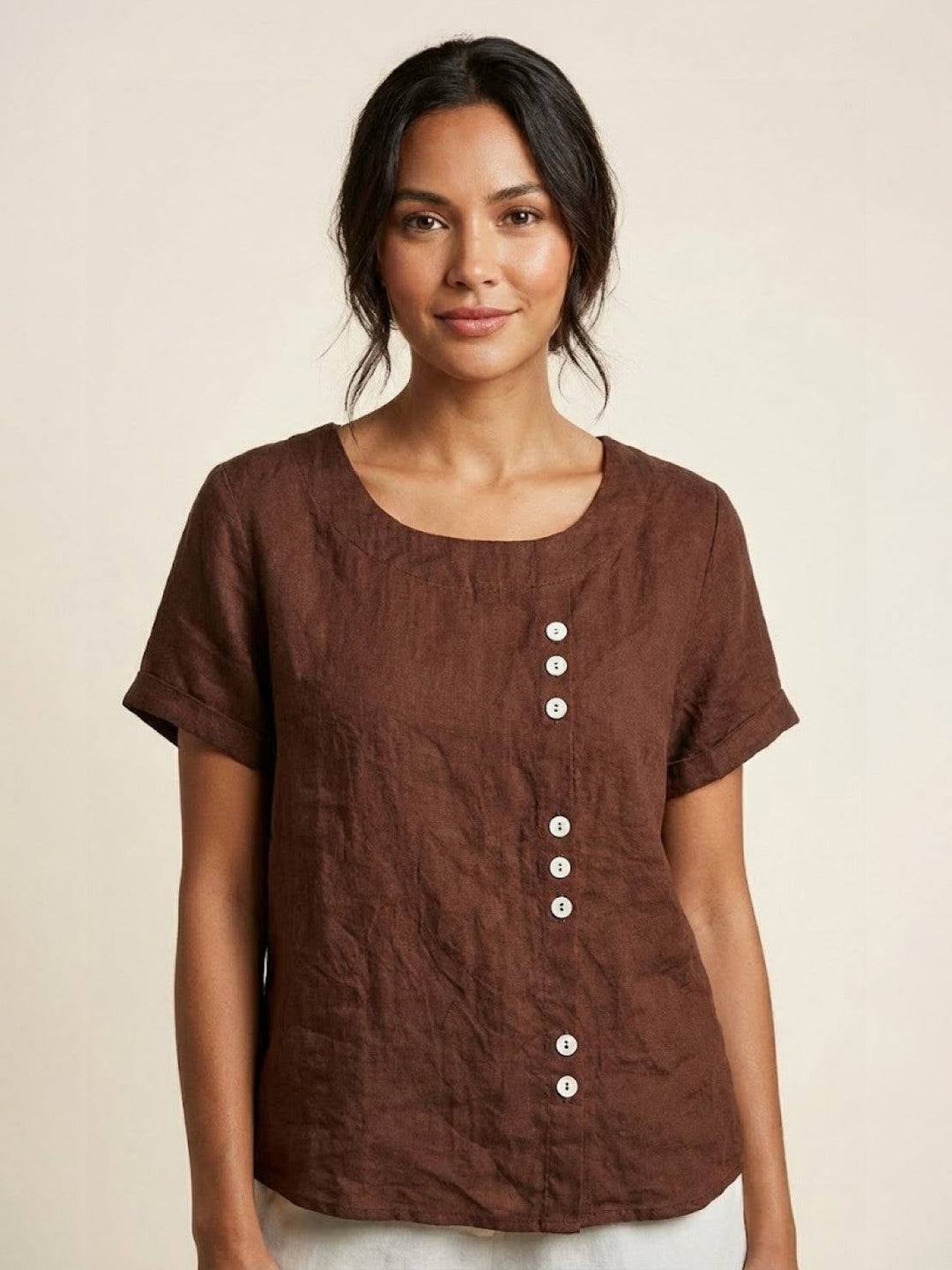 Close-up of asymmetric wooden-tone button detail on Foreen short sleeve top in Army Green