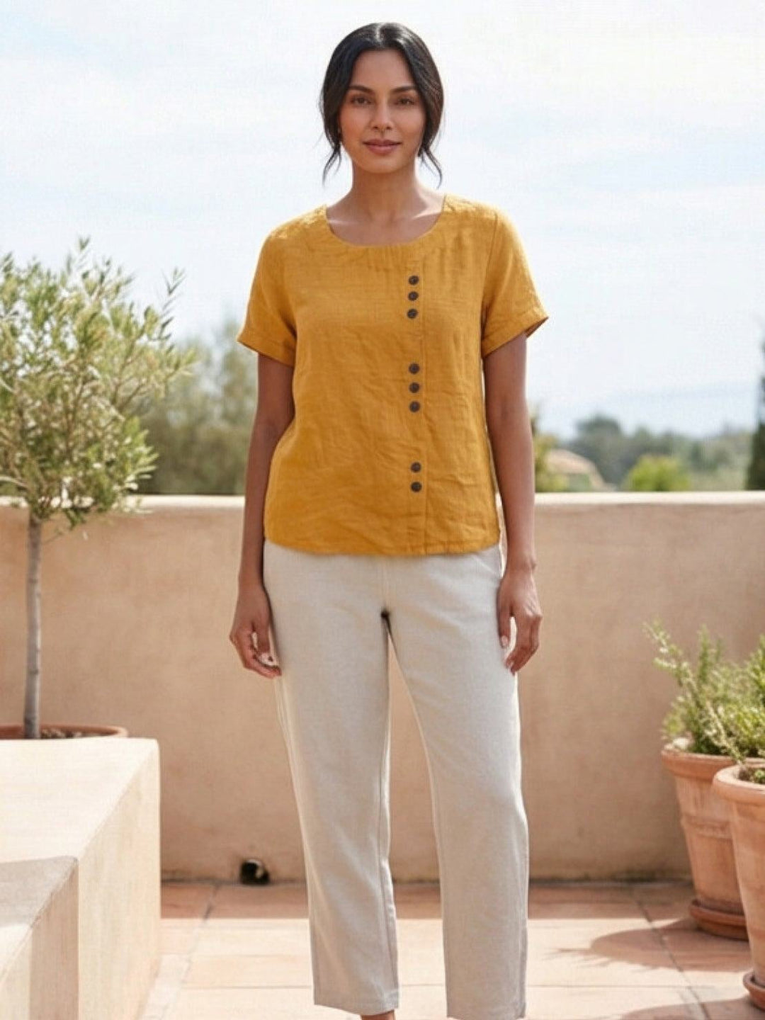 Flat lay of Foreen top in Orange showing scoop neckline and button accent