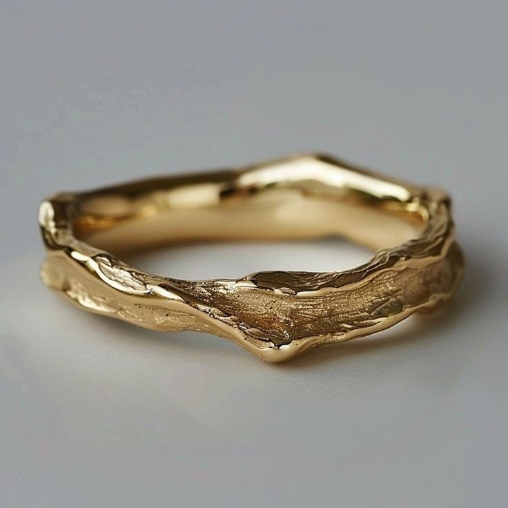 Close-up of a vintage hammered gold ring with artisan textured surface, shown on a neutral background