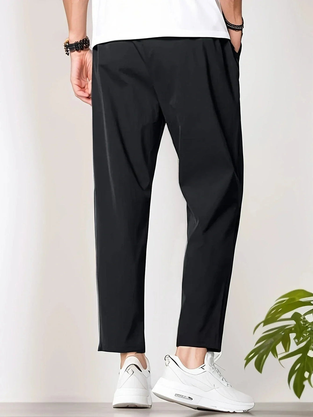 Model wearing black FormaFit casual pants styled with a button-down shirt, side view