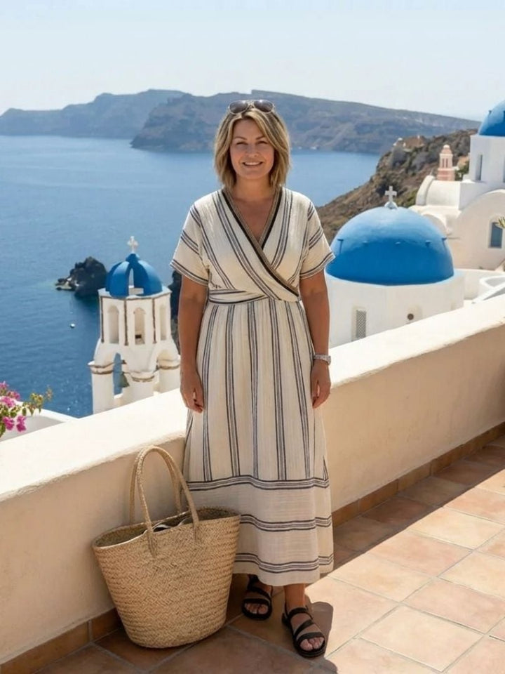 Side view of a woman in a flowing white striped wrap midi dress highlighting the midi length