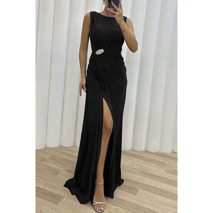 Close-up detail of soft pleats on the Freesia maxi dress in black, highlighting light-catching fabric texture