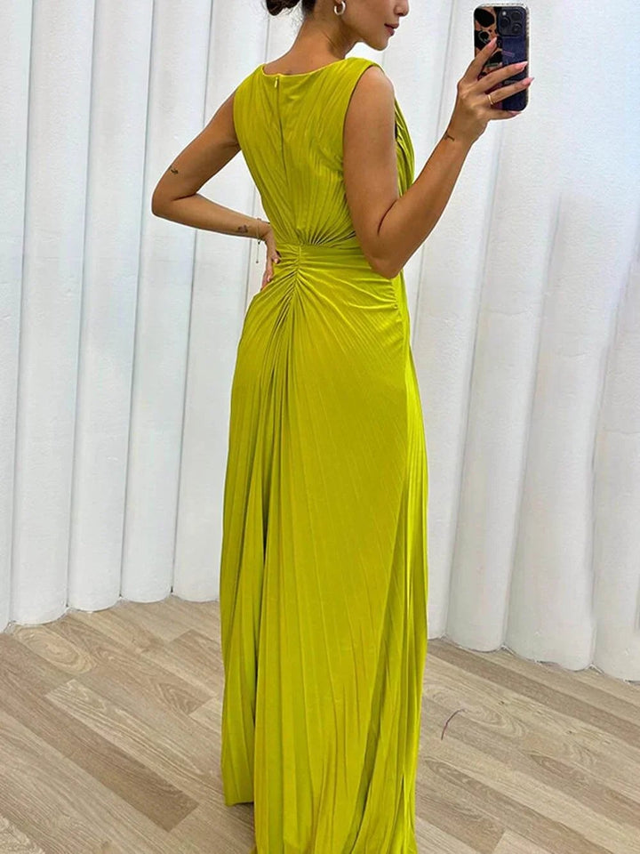 Full-length side view of model in the Freesia pleated maxi dress showing elongating silhouette and maxi length