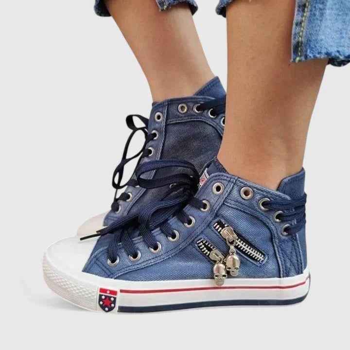 Freya denim blue high-top sneaker side profile showing chunky decorative zip pull and stripe midsole