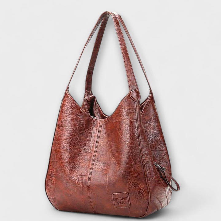 Black minimalist shoulder bag with sleek lines and comfortable straps, front view
