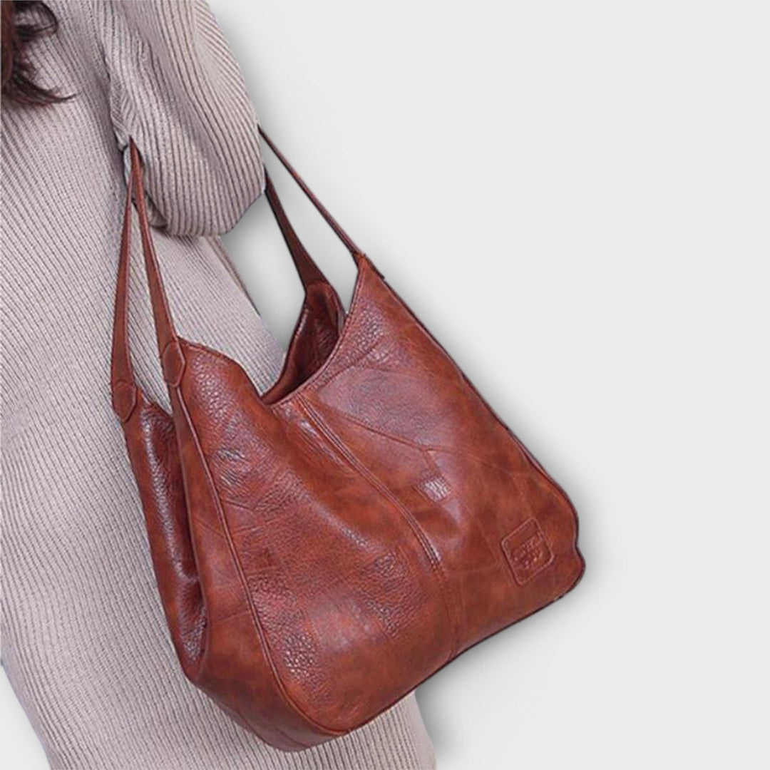 Brown shoulder bag with spacious interior and structured silhouette, side angle