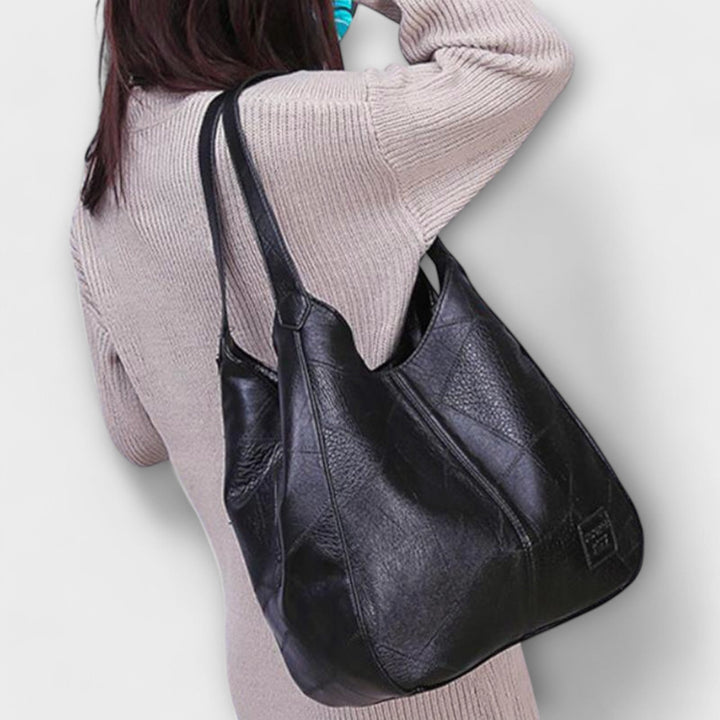 Dark brown minimalist shoulder bag displayed to show strap length and bag depth