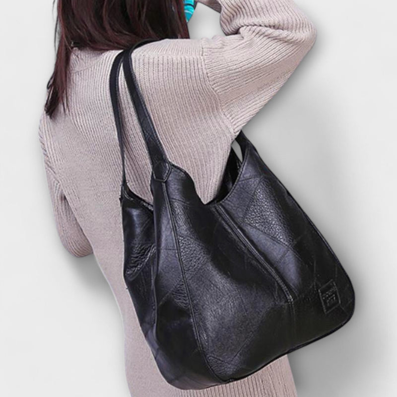 Dark brown minimalist shoulder bag displayed to show strap length and bag depth