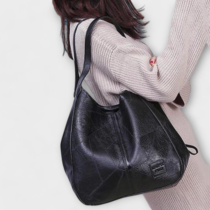 Close-up of shoulder bag hardware and strap detail in black