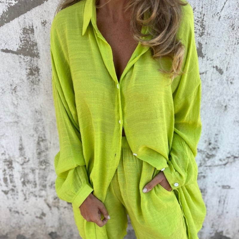 Woman tying the Funa blouse at the waist for a casual, relaxed look