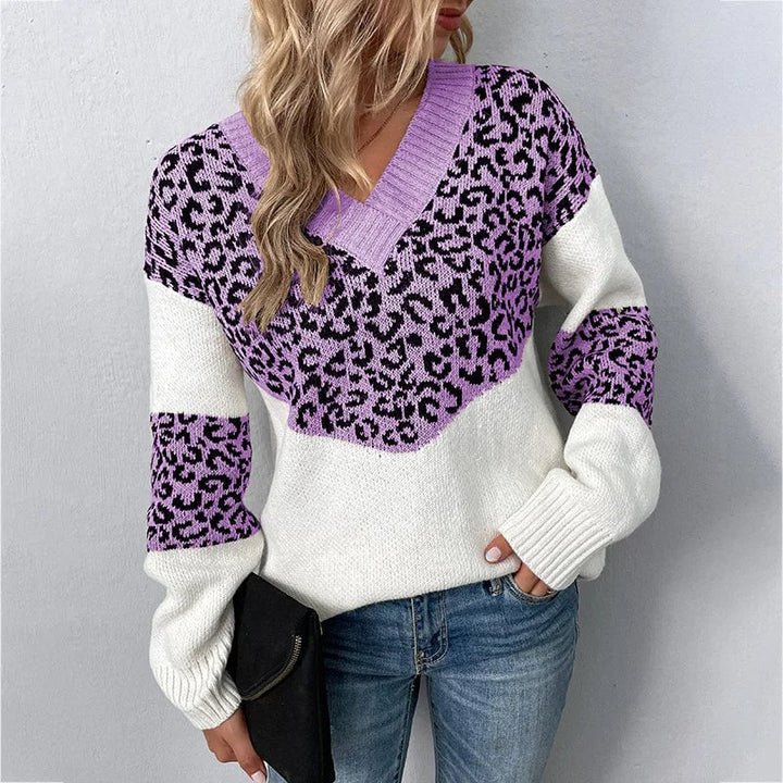 Woman wearing a beige V-neck leopard print sweater layered over tailored trousers for a refined everyday outfit