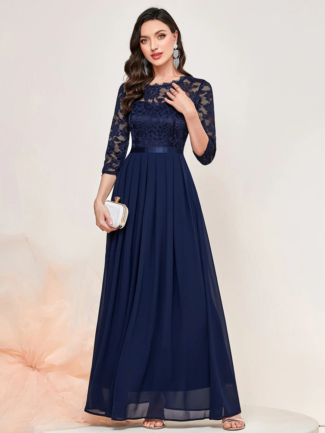 Model wearing a green lace pleated quarter-sleeve formal maxi dress with flowing pleated skirt
