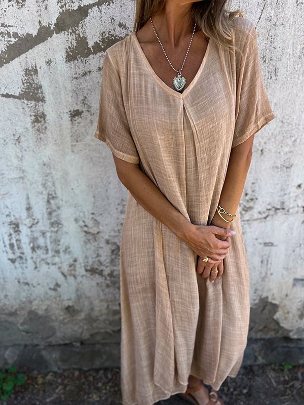 Back view of women's flowy maxi dress in orange highlighting draped design