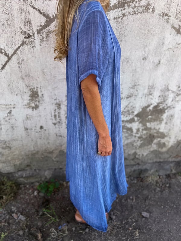 Detail shot of lightweight breathable fabric on orange draped maxi dress