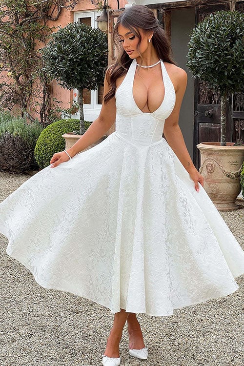 Model in a white sleeveless halterneck jacquard maxi dress styled for a summer celebration