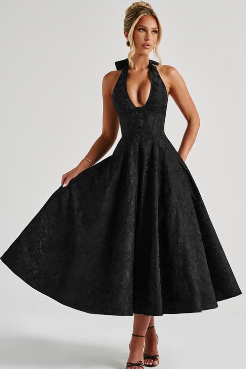 Side view of a wine red halterneck jacquard maxi dress showing the flared skirt and elongating silhouette