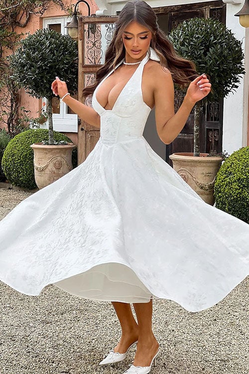 Model wearing a pink jacquard halterneck maxi dress at a summer celebration