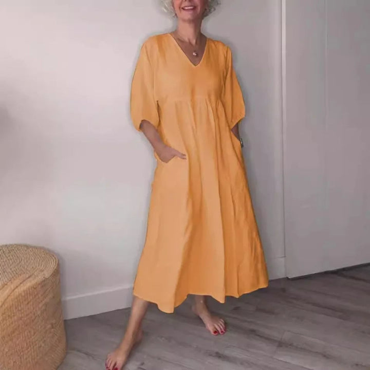Woman wearing a white v-neck draped midi dress with tummy control and side pockets, front view