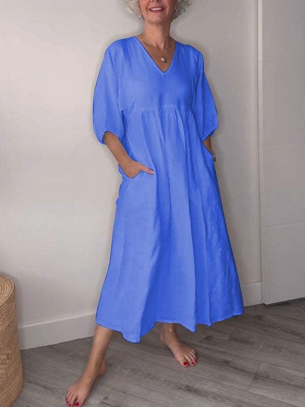 Side view of a white draped midi dress showing the flowing silhouette and midi length